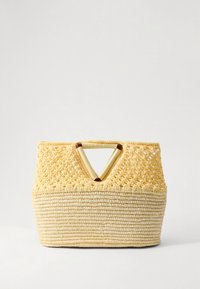Yellow woven straw bag with a structured shape, open top, and V-shaped cutout handle. Textured surface with a smooth base.