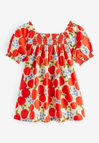 Mønstret bluse med røde æbler og blå bær på en beige baggrund. Korte, puffede ærmer med smocket udskæring. Materialet er i bomuld.