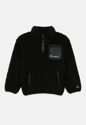 Pullover de fleece preto com colarinho de botão de pressão, bolso no peito com ziper e logótipo da Champion, bolsos laterais e emblema da Champion na bainha da manga esquerda.