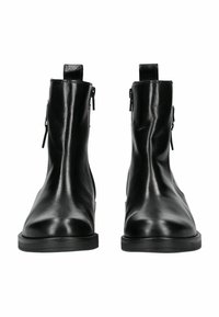 Botines de cuero negro con un acabado suave, punta redonda, cremalleras laterales y suelas de goma planas. Diseño minimalista sin patrones visibles.