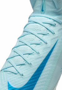 Scarpa sportiva azzurro chiaro con tomaia in mesh testurizzato, grande Nike swoosh blu e lacci piatti dello stesso colore.