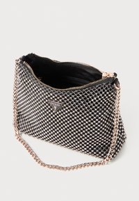 Black mesh handbag with metallic accents, zip closure, and a patterned surface. Features a gold chain strap and branded logo at the front.