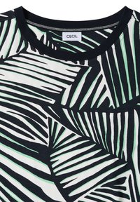 Chemise rayée noire et blanche avec des accents verts et un col rond noir montrant une petite étiquette blanche avec le nom de la marque CECIL.