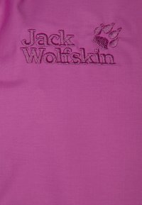 Rosa tyg med "Jack Wolfskin"-logotypen i mörkare rosa broderi tillsammans med ett tassgrafik. Slät textur, enhetlig färg.