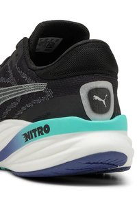 Scarpa sportiva nera con tomaia in mesh a fantasia, dettagli argentati e una suola robusta bianca, menta e blu navy con il marchio "NITRO".