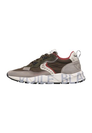 Sneaker basse in verde oliva, beige e rosso con chiusura frontale con lacci e suola bianca spessa con grande testo stampato.