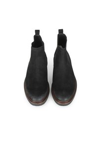 Botas de tobillo de ante negro con punta redondeada, paneles laterales elásticos y lengüetas para tirar. Confeccionadas con un ribete de cuero marrón a lo largo de la suela.