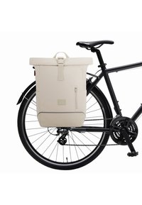 Tej színű rolltop hátizsák, tartós anyagból készült, elülső cipzáros zsebbel, logópacával, és egy fekete kerékpárvázhoz rögzítve.