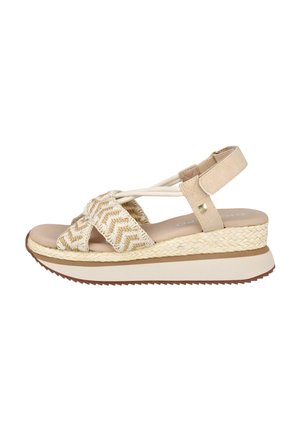 Sandalia de cuña beige con tiras de tela tejidas en zigzag, correa elástica para el tobillo con Velcro y suela gruesa texturizada con detalle trenzado.