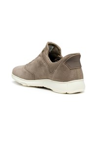 Sneaker in suede marrone chiaro con una texture liscia, lati elastici per una facile vestibilità e una suola in gomma bianca, caratterizzata da un accento in pelle marrone sul tallone.