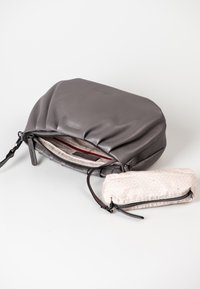 Gray leather handbag with gathered design and a zippered closure. Includes a small pink patterned pouch with zipper and leather accents.