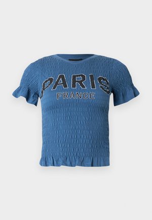 Blå kortærmet smock-top med flæsekant og teksten "PARIS FRANCE" i sort-hvide bogstaver på tværs af brystet.
