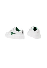 Des sneakers blanches avec des accents verts pr�ésentent une semelle en caoutchouc, un bout arrondi, des détails cousus et une bande métallique brillante à l'arrière.