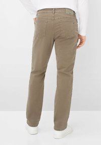 Braune Baumwollhose mit geradem Bein. Verfügt über zwei Gesäßtaschen, dezente Nahtdetails und ein Logo am Bund.