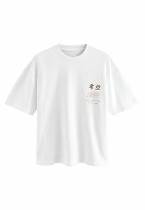 T-shirt blanc à manches courtes avec col rond, présentant un petit motif floral et un texte japonais sur la poitrine gauche.