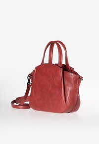 Borsa a mano in pelle rossa con due manici corti e una tracolla staccabile. Texture liscia, design strutturato e dettagli del logo discreti sul lato.