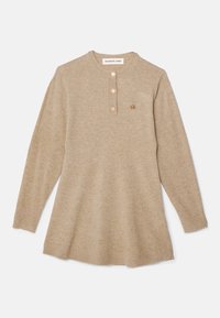 Beżowy sweter z długim rękawem, z kołnierzykiem henley, trzema guzikami i kieszonką na lewej piersi. Miękka tekstura i luźny krój.