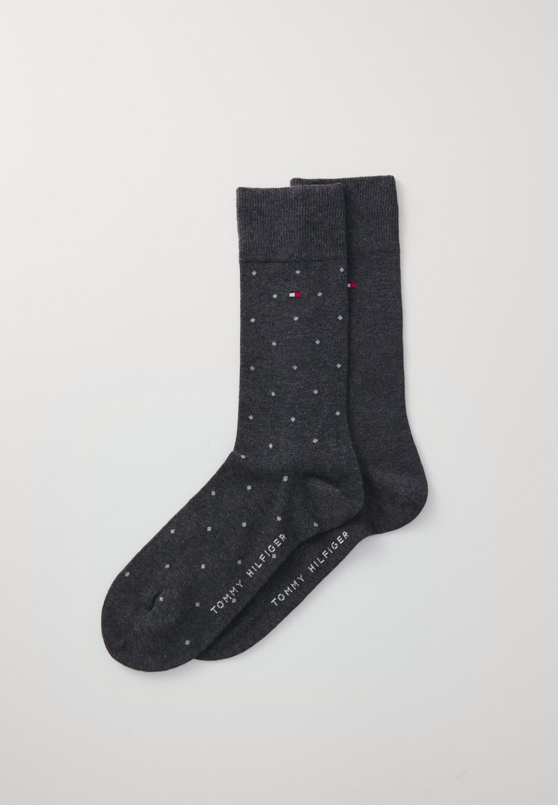 Calcetines gris oscuro con pequeños lunares blancos y rojos, puño acanalado y marca "TOMMY HILFIGER" en la parte inferior. La textura parece suave.