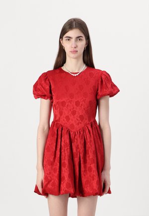 Rød kjole med pufferm, teksturert blomsterdesign, A-linjeform og en tettsittende overdel. Har en rund halslinje og en samlet skjørt.