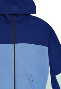 Felpa con zip di colore blu navy e azzurro chiaro, dotata di cappuccio, con una texture morbida, blocchi di colore a contrasto e una tasca frontale.