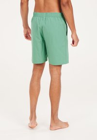 Groene zwembroek met een elastische tailleband, zijzakken en een lichtgewicht stof; platte naden en een casual pasvorm.