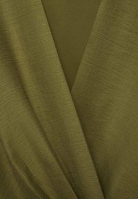 Tissu vert olive avec une surface lisse, légèrement texturée, présentant un design drapé et superposé qui crée un effet de couches.