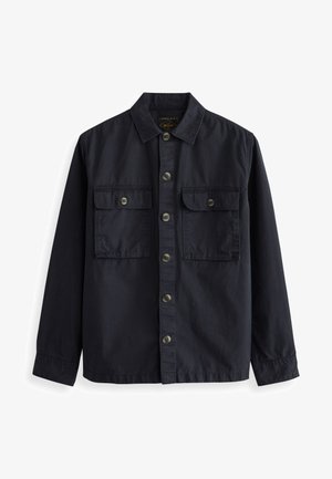 Navy button-up shirt in cotton fabric, featuring a pointed collar, two front pockets with flaps, and brown buttons. Smooth texture.