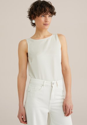 Haut sans manches blanc avec une texture lisse et un col rond, associé à un jean blanc taille haute. Design simple et minimaliste.