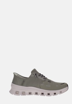 Baskets de sport gris clair avec tige en mesh, lacets noirs, et semelle épaisse blanche avec découpes de ventilation, vue de côté sur fond blanc.