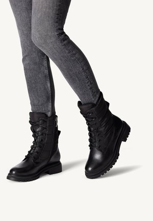 Black leather ankle boots with lace-up front, padded collar, and side zipper. Features a textured sole for grip and a smooth finish.