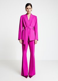 Fuchsia maßgeschneiderter Anzug mit Wickeldesign, langen Ärmeln und weit geschnittenen Hosenbeinen. Enthält einen passenden Gürtel und minimalistische Taschen.