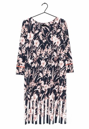 Robe à motifs floraux avec un fond bleu marine foncé, ornée de fleurs roses claires et de feuilles vertes, en tissu doux et avec un ourlet rayé.