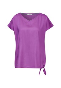 Blusa viola a maniche corte con scollo a V e dettaglio con fiocco laterale. Realizzata in un materiale morbido e leggero con un fit comodo.