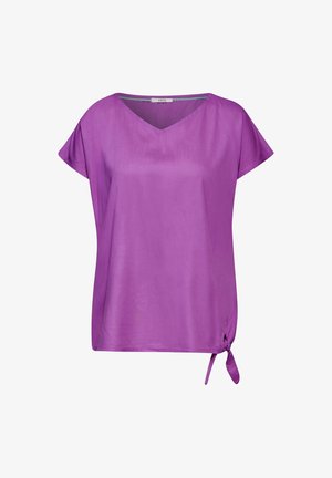 Blusa corta de manga corta en color púrpura con escote en V y un detalle de lazo en el lateral. Fabricada con un material suave y ligero, tiene un corte relajado.