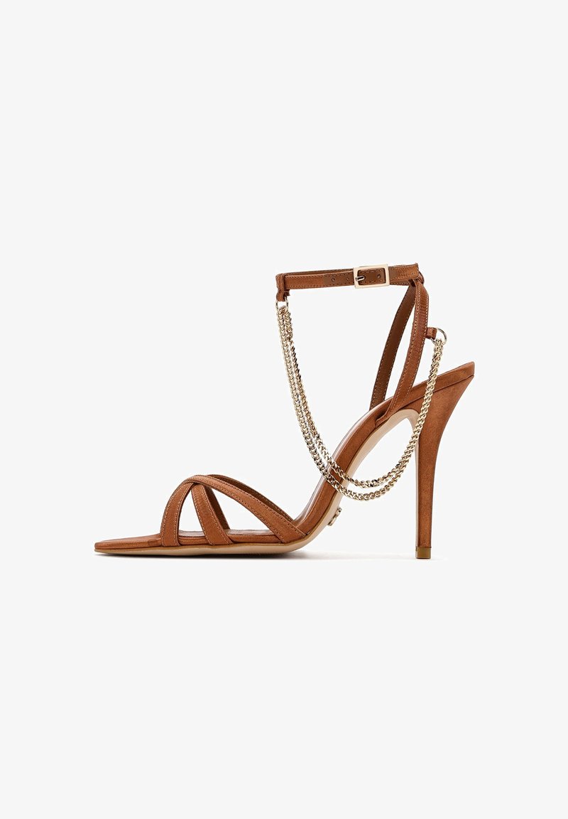 Braune Wildleder-Peeptoe-Sandalen mit dünnen Riemen, einem geschnallten Knöchelriemen und einer dekorativen Kette entlang der Rückseite. Glatte Sohle.