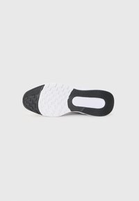 Semelle en caoutchouc avec une surface texturée et une base blanche, comportant des accents noirs et un motif de grip pour l'adhérence.