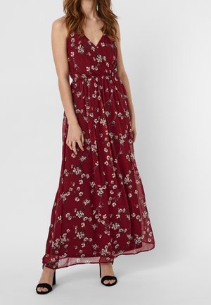 Robe maxi bordeaux avec un motif floral. Présente un décolleté en V, un design sans manches et un tissu fluide. Accentuée par une taille cintrée.