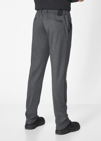 Gray trousers with a textured fabric, relaxed fit, back pockets, and an elastic waistband. Paired with black footwear.