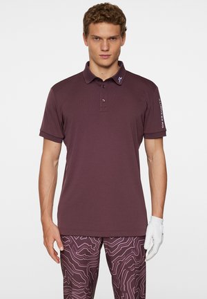 Bordeaux polo t-shirt med en treknaps placket, korte ærmer og et logo på kraven. Sammen med mønstrede bordeaux bukser.
