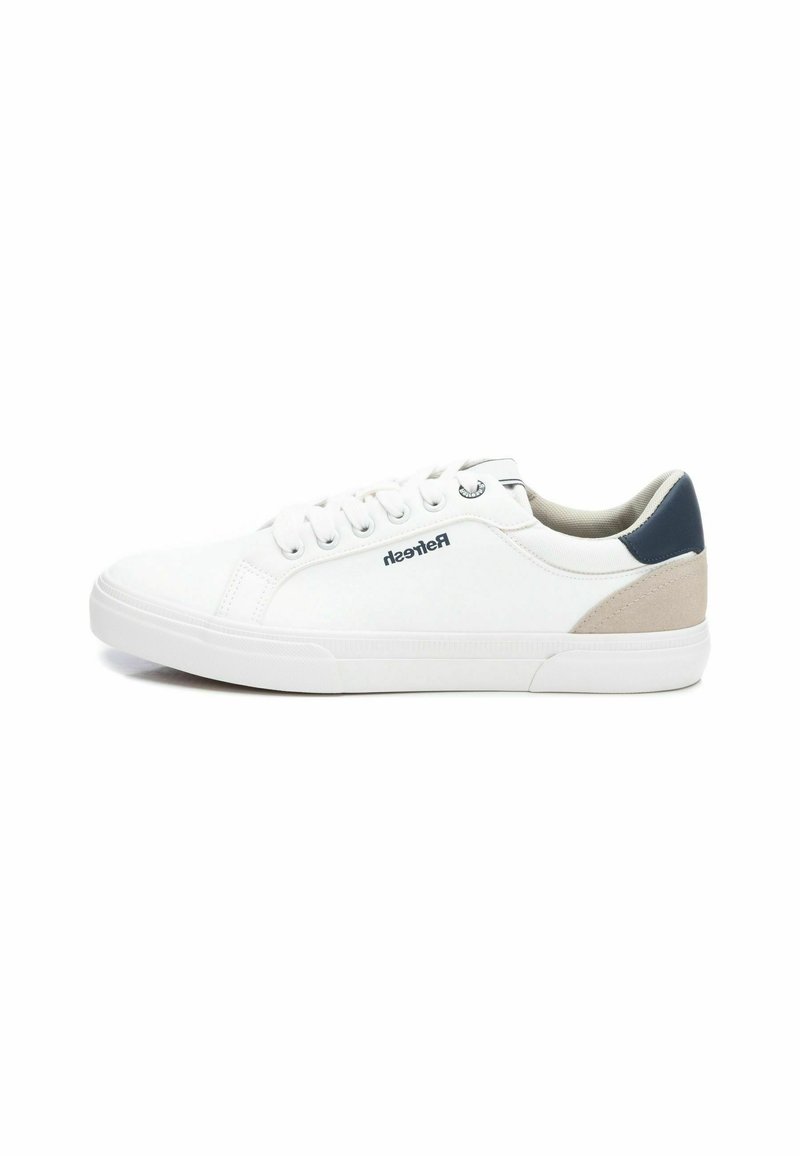 Zapatilla blanca con parte superior de cuero suave, punta redonda, suela de goma plana, cierre de cordones en la parte delantera y acentos contrastantes en azul marino y beige en el talón.