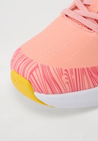 Roze sportshoe met een textuur bovenwerk, featuring een golvend patroon en een gele accent op de zool. Witte tussenzool zorgt voor contraste.