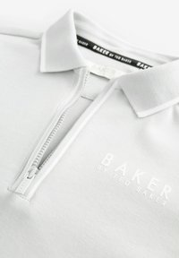 Světle šedé polokošile se zipovým uzávěrem, plochým límečkem a vyšitým logem "BAKER" v bílé barvě. Vyrobené z měkké, texturované tkaniny.