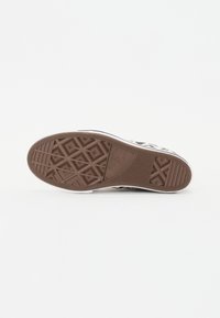 Brun gummisåle med diamantmønster, hvite sidevegger og svart og beige kanvasoverdel med dyreprintdesign.