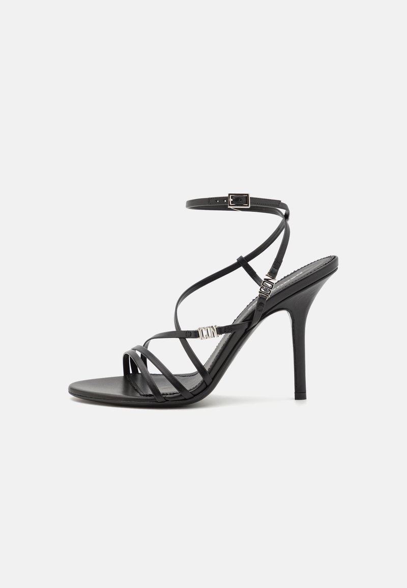 Sandalha preta de salto alto com tiras finas, fivela no tornozelo, superfície de couro suave e salto stiletto esguio.