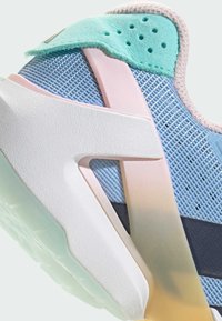 Sport shoe with a blue mesh upper, mint green accents, and a textured white sole. Features a pink plastic overlay and smooth black stripe.