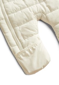 Cream-colored quilted wrap or pillow with a U-shaped cutout and padded pocket against a white background.