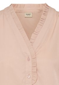 Pirosító rózsaszín blúz v-nyakkivágással, fodros szegéllyel és háromgombos záródással, sima, enyhén texturált anyagból készült.