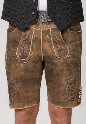 Traditionelle braune Lederhosen-Shorts mit bestickten Hirschmotiven, getragen mit einer dunklen gemusterten Weste und einem Gürtel mit silberner Schnalle.