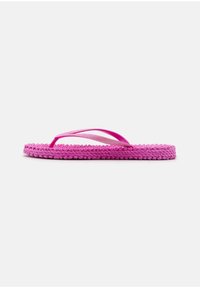 Infradito rosa con texture intrecciata, caratterizzate da sottili fasce e un accento luccicante. La suola è piatta e ampia, progettata per un uso informale.