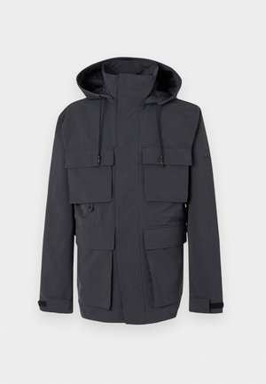 Σκούρο γκρι μπουφάν με κουκούλα και ψηλό γιακά, ρυθμιζόμενα κορδόνια, μπροστινό φερμουάρ καλυμμένο με πατιλέτα και τέσσερις μεγάλες τσέπες με πατιλέτα.